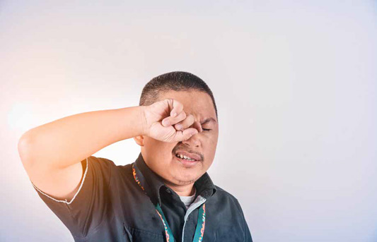 Person avoiding touching their eyes to prevent virus transmission